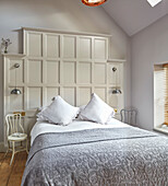 Bedroom and decorative wall paneling with chairs as side tables