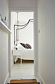 Blick in weißes Schlafzimmer auf Doppelbett mit Baldachin