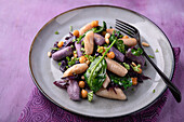 Colourful gnocchi with red cabbage, spinach, chickpeas and pine nuts