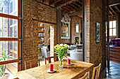 Dining area in an open plan room with brick walls