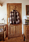Chequered jacket hanging on wooden door