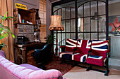 Three seater with Union Jack cover in front of industrial glass wall in the study