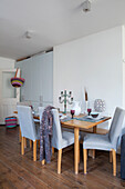 Chairs with light blue loose covers around table in dining area