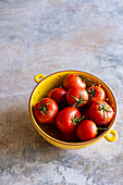 Organic Vine Tomatoes in Yellow Ceramic Colander