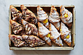 Selection of chocolate and lemon croissants in a box