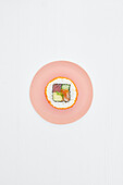 Eine Sushi Rolle auf rosa Teller