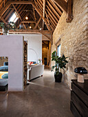 View of living room area with large double sided fireplace in a former barn