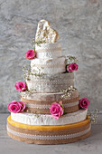 Cheese Wedding Cake - wheels of Cheeses arranged as a multi-tier wedding cake, with rose petals