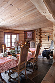 Rustic dining area in log cabin with candles and flower arrangement