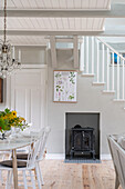 Dining area with wood-burning stove and staircase in a light country style