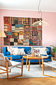 Living room with blue sofa, tapestry and pendant light