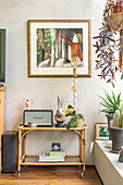 Serving trolley as side table with decorative objects and plant