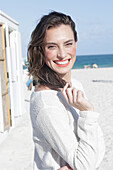 Brunette woman in light jumper on the beach