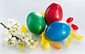 Colorful Easter eggs, sugar eggs, and flower sprig