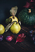 Herbststilleben mit Quitten, Pflaumen, Trauben und Kürbis