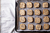 Ungebackene, hausgemachte Shortbread-Plätzchen mit Nüssen und weißer Schokolade auf Backblech