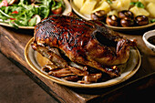 Holiday table with classic dishes roasted glazed duck with apples, boiled potatoes, green salad and sauce