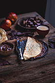 Crepes with chocolate spread on a rustic wooden background
