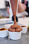 Schokoladencreme auf Cupcake spritzen