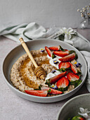 Erdbeer-Porridge mit Honig, Joghurt und Blüten
