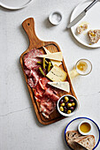 Charcuterie, cheese, pickles and olives on a board