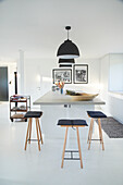 Modern kitchen with bar stools and black pendant lights