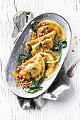 Ravioli with sautéed sage leaves, toasted pine nuts, and brown butter