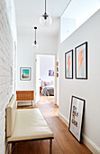 Hallway with white brick wall and artwork, view into the bedroom