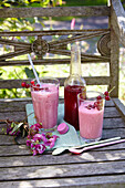 Redcurrant lassi with spring wort syrup on garden chair outside