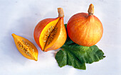 Hokkaido pumpkins: Whole, cut and a single slice (variety: Baby red hubbard)