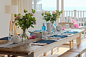 Set dining table with flower arrangements and sea view