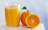 Ein Glas Orangensaft, daneben Orangen