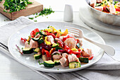 Dish with salmon, colorful peppers and zucchini