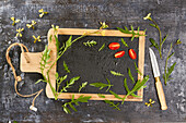 Rucola und Tomaten auf Holzbrett mit Schiefertafel