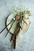 Minimalistic table setting in grey colors decorated with pink carnation flowers