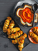 Mumien-Würstchen und Hexenkessel (Kürbis mit schwarzem Sesam) mit schleimigen Tomaten-Dip