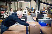 Man packaging a client order in a warehouse.