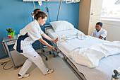 Nurses attaching a restraint band to a patient's bed