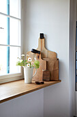 Wooden boards and vase with wild flowers on window sill