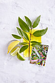 Lemon and lime slices, twig with lemon leaves and a photo of a lemon scented teatree (scent lemony, refreshing)