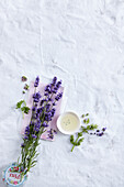 Lavendelblüten, Blätter von Rosengeranie, Schälchen mit Aromaöl, Blüten von Muskatellersalbei