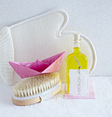 Massage glove, jojoba oil, body brush, and paper origami boat (spring cure, lightness, cleansing)