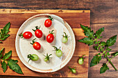 Red and green grape tomatoes on a ceramic plate