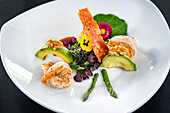 Salad with avocado, cress, green asparagus, walnuts, and grilled prawns