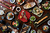 Auswahl an japanischen Gerichten: Sushi, Terayki-Spieße und Gyoza