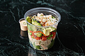 Gesunde Bowl mit Avocado, Meeresfrüchten und Quinoa zum Mitnehmen
