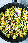 Potato and broccoli with feta in a pan