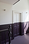 Hallway on the upper floor painted in dark purple and white