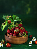 Strawberries and wild berries in a wooden bowl