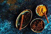Turmeric, star anise, cloves, and cinnamon stick in bowls